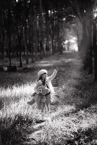 Full length of girl on field in forest