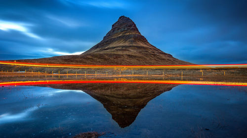 Reflection of kirkjufell and light trail on lake at dusk