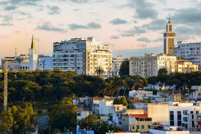 Buildings in city against cloudy sky