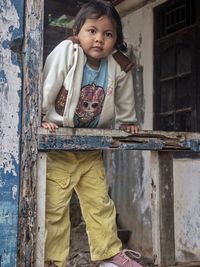 Portrait of boy standing by railing