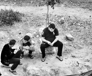 Full length of men sitting outdoors
