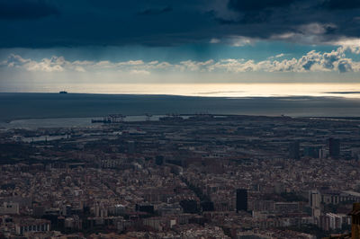 Aerial view of cityscape by sea against sky