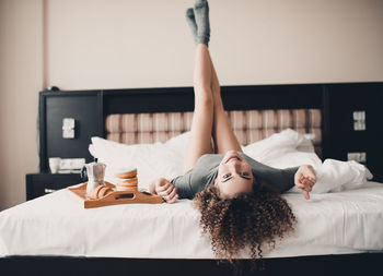 Portrait of young woman lying on bed at home