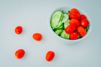 High angle view of cherries in bowl against white background