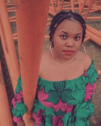 Close-up portrait of woman standing by pink flowers