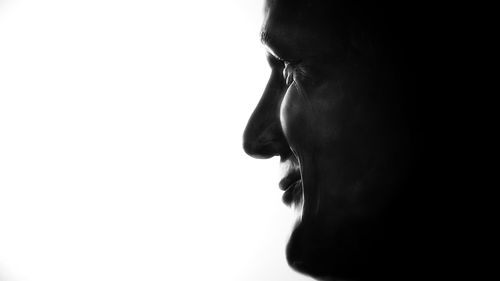 Close-up portrait of a teenage girl looking away over white background