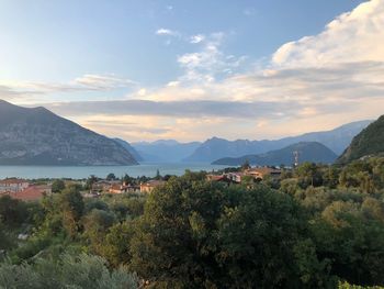 Scenic view of townscape by mountains against sky