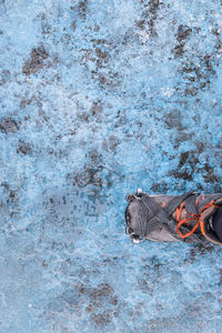 High angle view of foot walking on ice