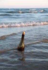 Close-up of bottle on beach