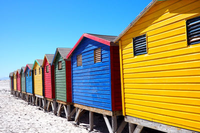 View of beach huts against clear blue sky