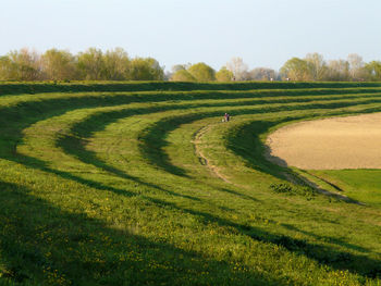 Scenic view of grassy field against sky