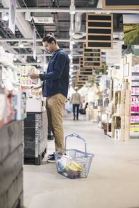 Side view of man buying groceries in supermarket