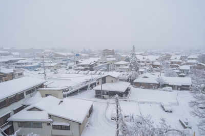 High angle view of snow covered houses against clear sky