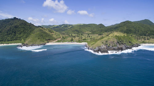 Scenic view of sea and mountains against blue sky