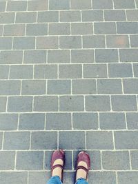 Low section of woman standing on footpath