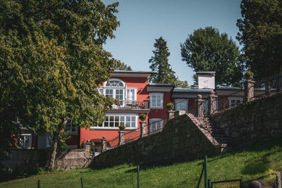 Houses by trees against sky