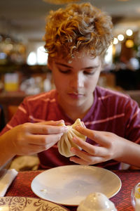 Teenage boy having food at restaurant
