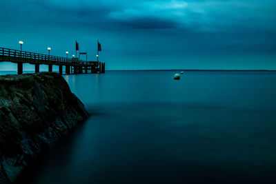 Long exposure of a pier with a breakwater in the foreground