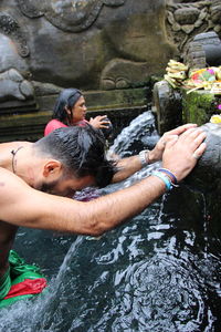 Man taking bath in fountain at temple