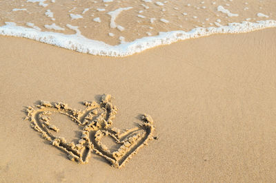 High angle view of heart shape on sand at beach