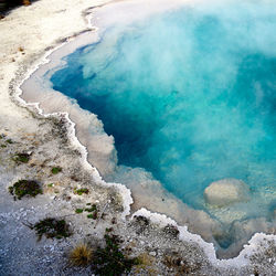 High angle view of smoke emitting from turquoise hot spring