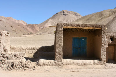 Built structure on desert against clear blue sky