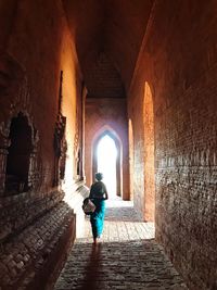 Rear view of man walking in corridor