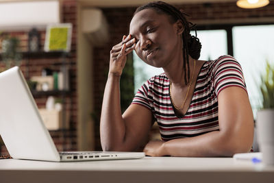 Young woman using laptop at table