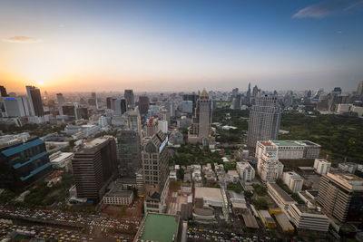 High angle view of modern buildings in city against sky during sunset