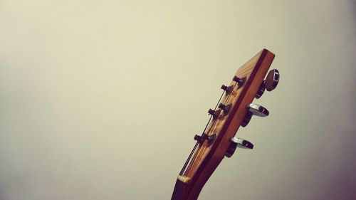 Close-up of guitar against wall