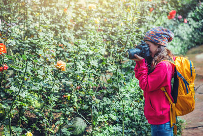 Full length of woman photographing plants