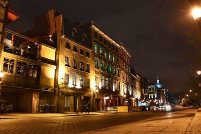 Illuminated buildings against sky at night