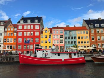 Red boat in city against sky