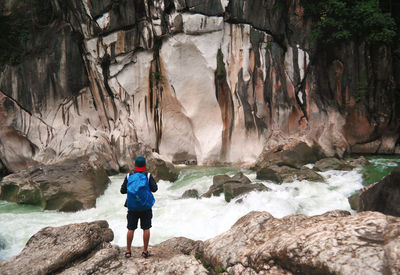 Rear view of man standing on rock formation