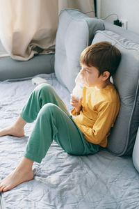 Young woman sitting on sofa at home