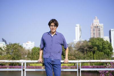 Portrait of smiling man standing against railing