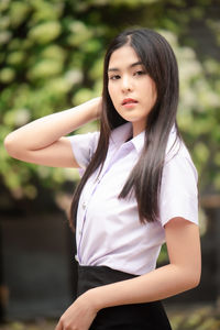 Portrait of a beautiful young woman standing outdoors