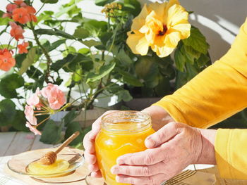 Close-up of hand holding yellow roses on table