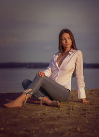 Portrait of young woman sitting at beach