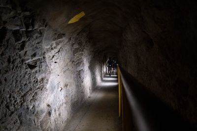 Rear view of man walking in tunnel