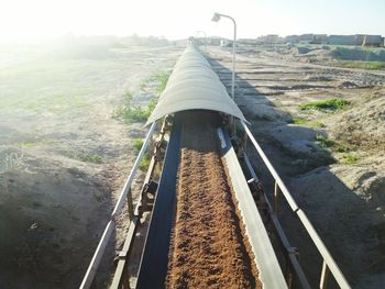 Panoramic view of railroad track amidst field against sky