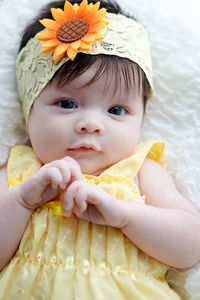 Close-up portrait of cute baby girl lying down