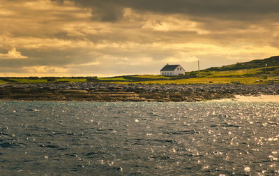 Beautiful seascape scenery of house at aran islands in ireland under dramatic cloudy skies