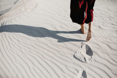 Low section of person standing on snow covered land