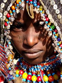 Close-up portrait of woman wearing colorful traditional jewelries