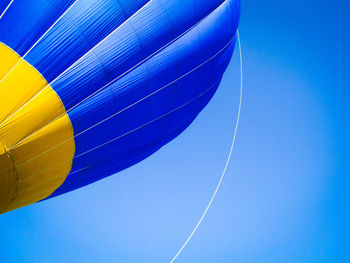 Low angle view of hot air balloon against clear blue sky