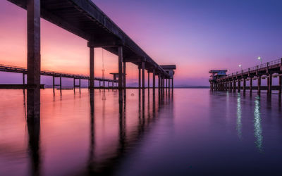 Pier over sea against sky during sunset