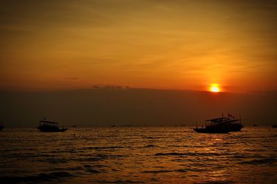 Silhouette boat sailing on sea against sky during sunset