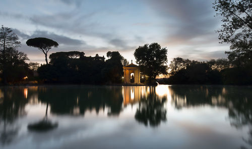 Reflection of trees in water against sky