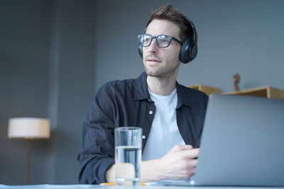 Man wearing headphones looking away in office